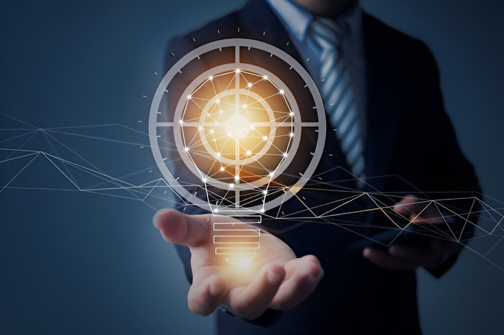 Businessperson’s outstretched hand holding a luminous holographic light‑bulb.
